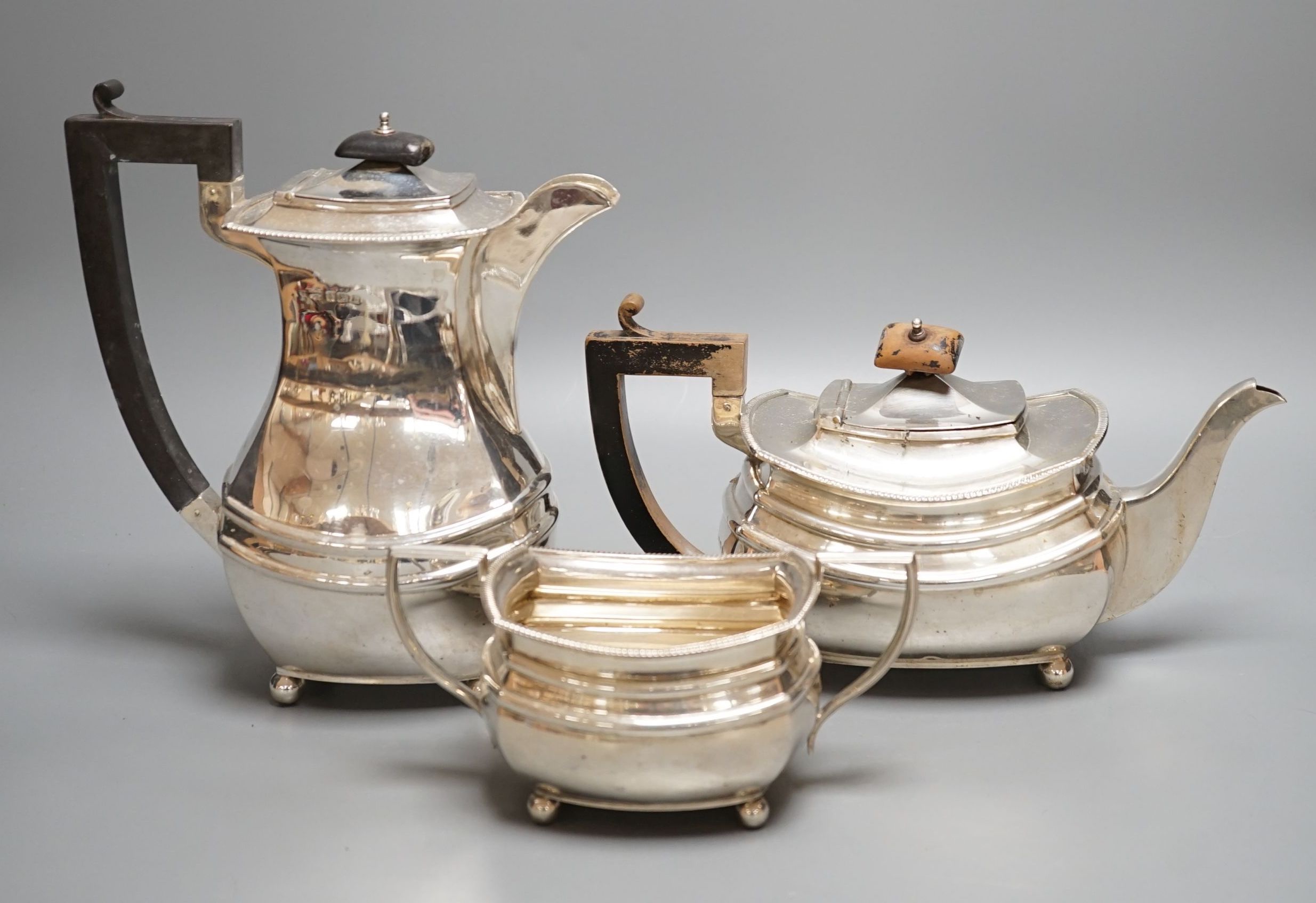 A George V matched silver part tea set, comprising a hot water pot, teapot and sugar bowl, different makers, Birmingham, 1927,8,9, gross 48.5oz.